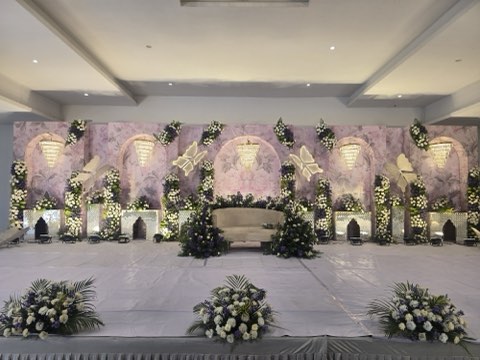 Lavender arched reception stage with floral pillars and chandeliers in the hall