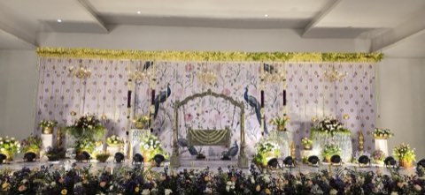 Peacock-themed wedding stage with floral canopy in the banquet hall, Airport Road, Hyderabad