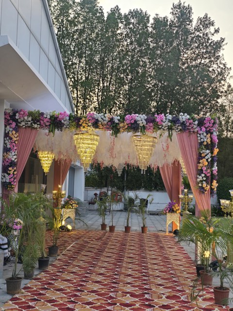 Pink floral entrance canopy with chandeliers at the main door of the convention hall