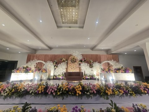 White orchid wedding stage with peach drapes and colourful floral border in the banquet hall on Airport Road