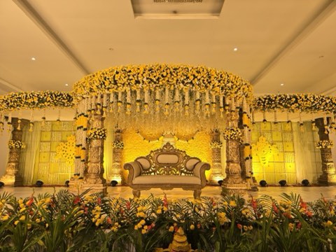 Yellow marigold wedding mandap with carved pillars and a golden sofa inside Hall 1